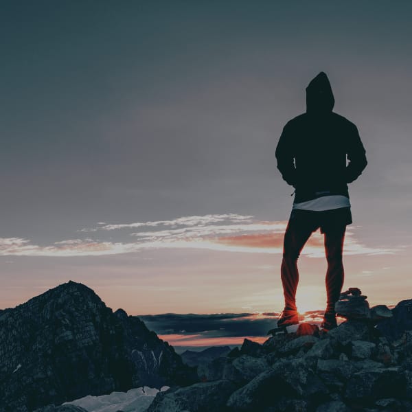 Person Standing on Rocks looking at sunset